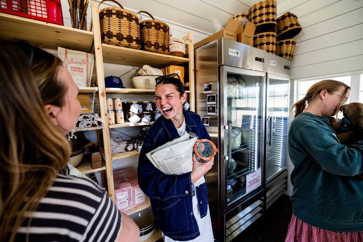 Molly Marquez, from Orem, center, laughs with a fellow customer while inside Ballerina Farm’s new farm stand in Kamas on Thursday, April 11.