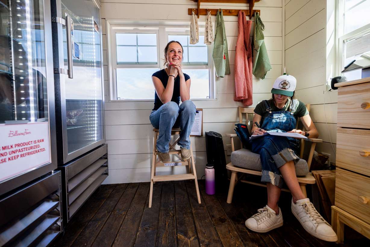 Employee Charlee Bell, left, talks to a fellow employee as employee Lilly Fryer, right, works on paperwork inside Ballerina Farm’s new farm stand in Kamas on Thursday, April 11.