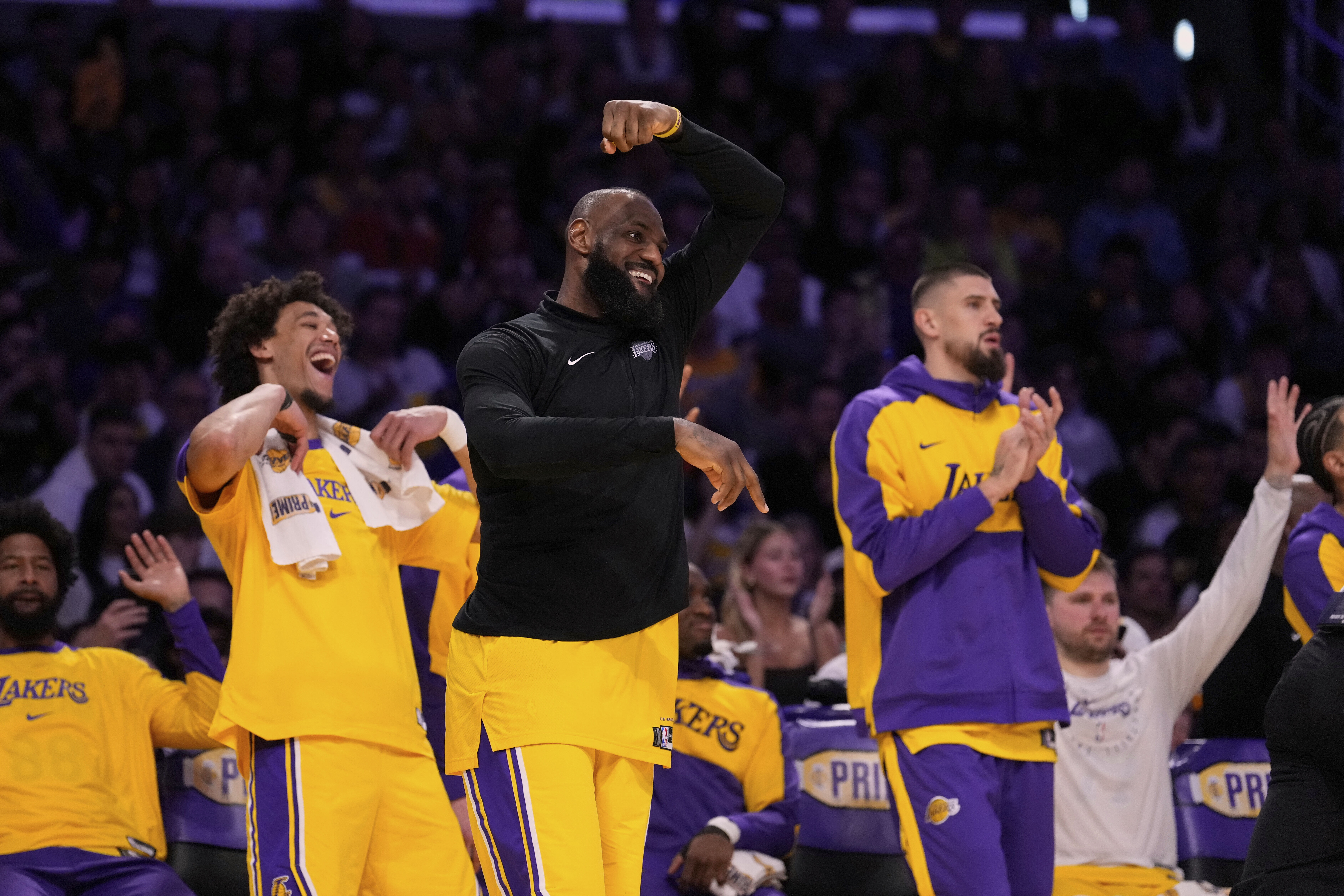 Los Angeles Lakers forward LeBron James, center, celebrates from the bench after the Lakers scored during the second half of an NBA basketball game against the Houston Rockets Friday, April 11, 2025, in Los Angeles.