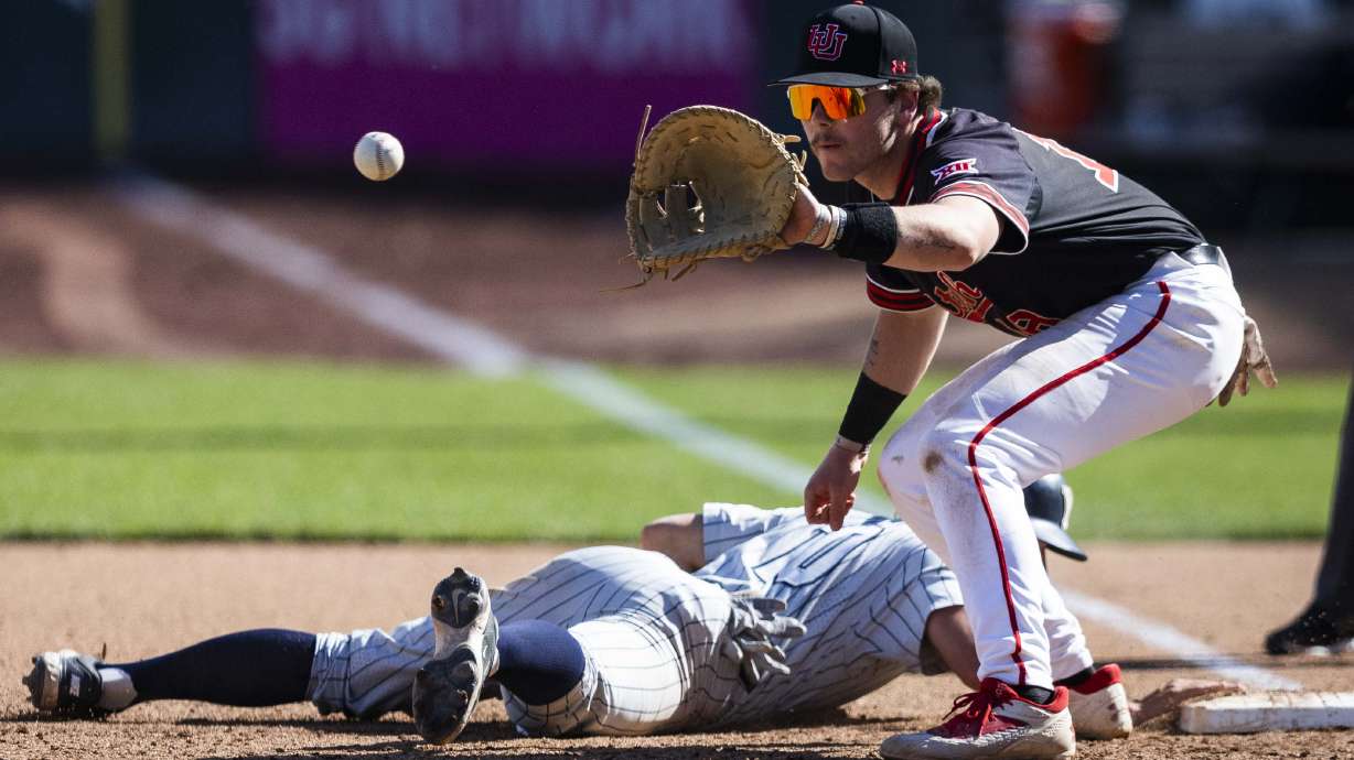 Utah infielder Cameron Gurney (18) catches a throw attempting to pick BYU catcher Parker Goff (10) off first base during a college baseball game between Utah and BYU at Smith's Ballpark in Salt Lake City on Saturday, April 12, 2025. Utah won the game with a final score of 9-6.