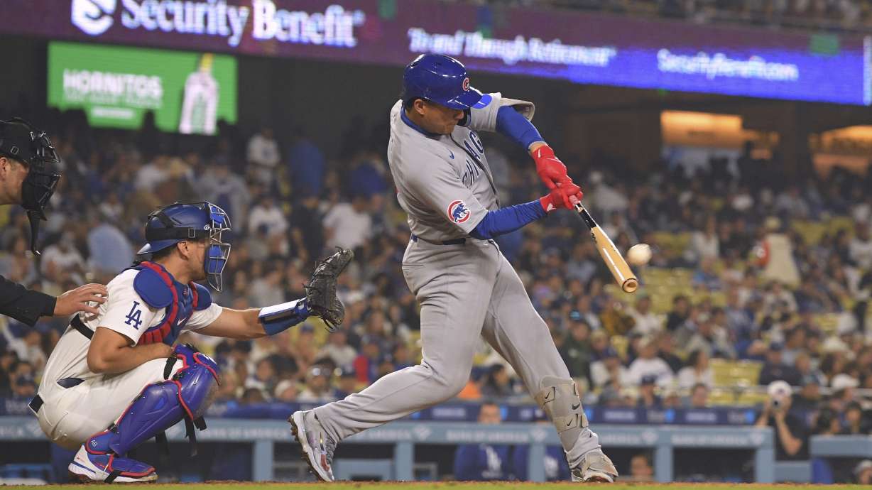 Chicago Cubs' Miguel Amaya, right, hits a two-run home run as Los Angeles Dodgers catcher Austin Barnes kneels at the plate during the eighth inning of a baseball game, Saturday, April 12, 2025, in Los Angeles.