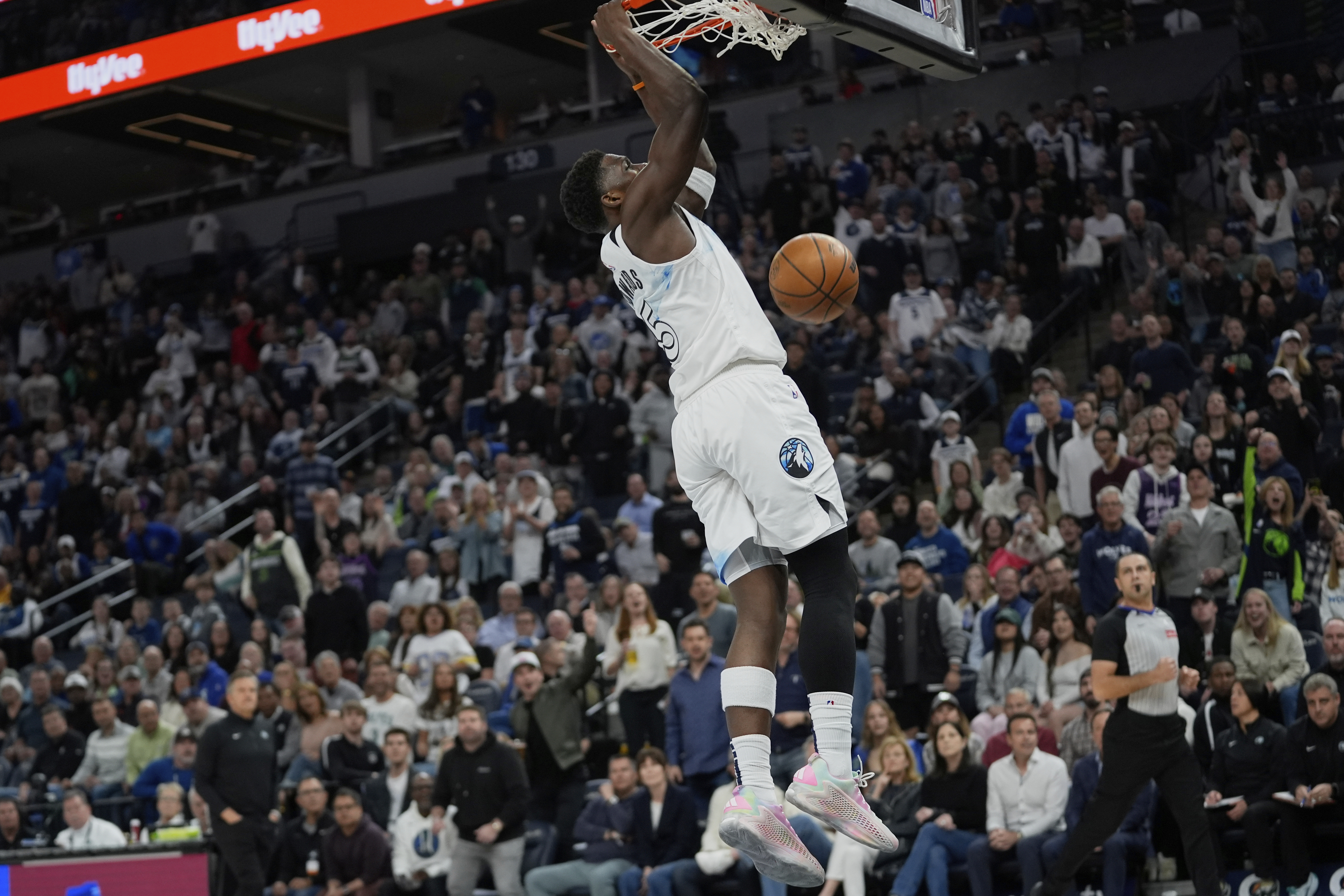 Minnesota Timberwolves guard Anthony Edwards hangs from the rim after making a basket during the first half of an NBA basketball game against the Brooklyn Nets, Friday, April 11, 2025, in Minneapolis. 