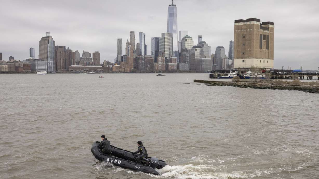 A New York Police Department scuba team looks for debris, Friday, where a sightseeing helicopter crashed a day earlier into the Hudson River in Jersey City, N.J. Federal regulators have grounded the tour company.