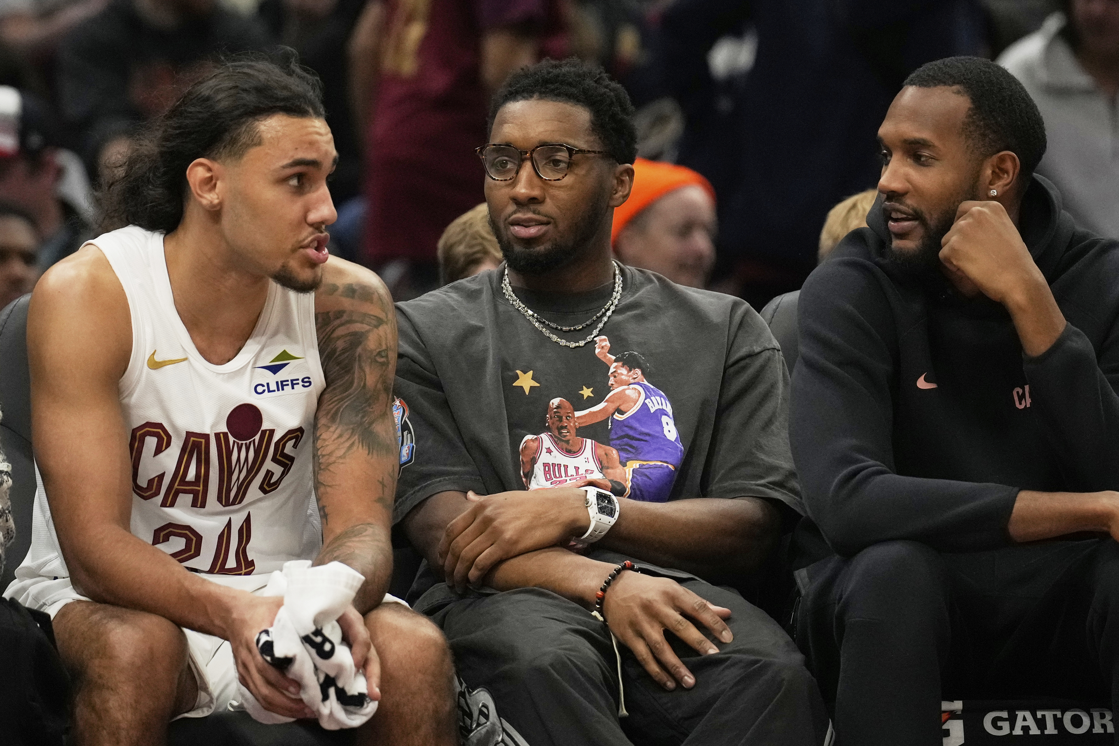 Cleveland Cavaliers forward Jaylon Tyson, left, talks with Donovan Mitchell, center, and Evan Mobley, right, who did not dress for the game, in the first half of an NBA basketball game against the Indiana Pacers Sunday, April 13, 2025, in Cleveland. 
