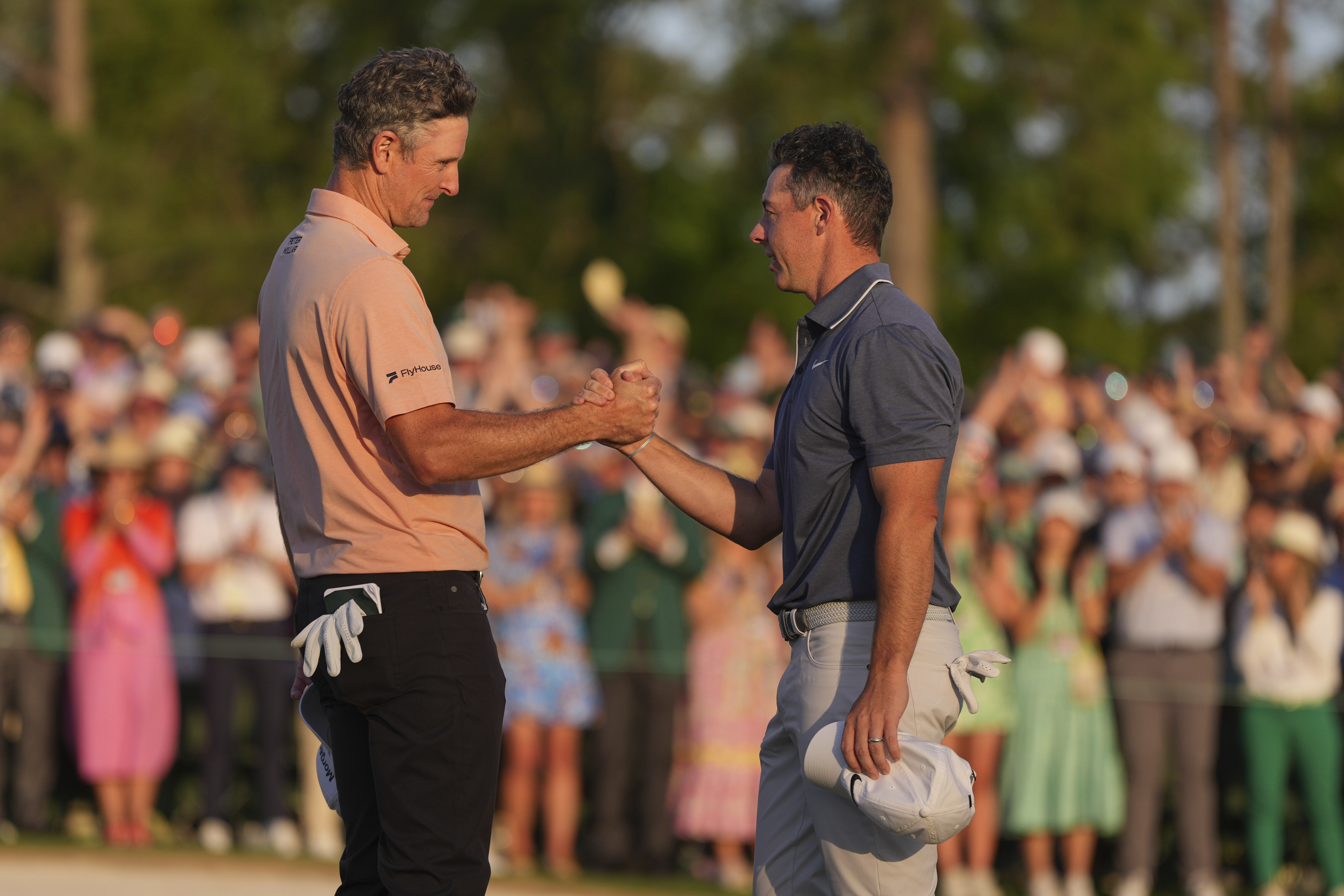 Rory McIlroy, of Northern Ireland, right, greets Justin Rose, of England, after winning in a playoff after the final round the Masters golf tournament, Sunday, April 13, 2025, in Augusta, Ga.