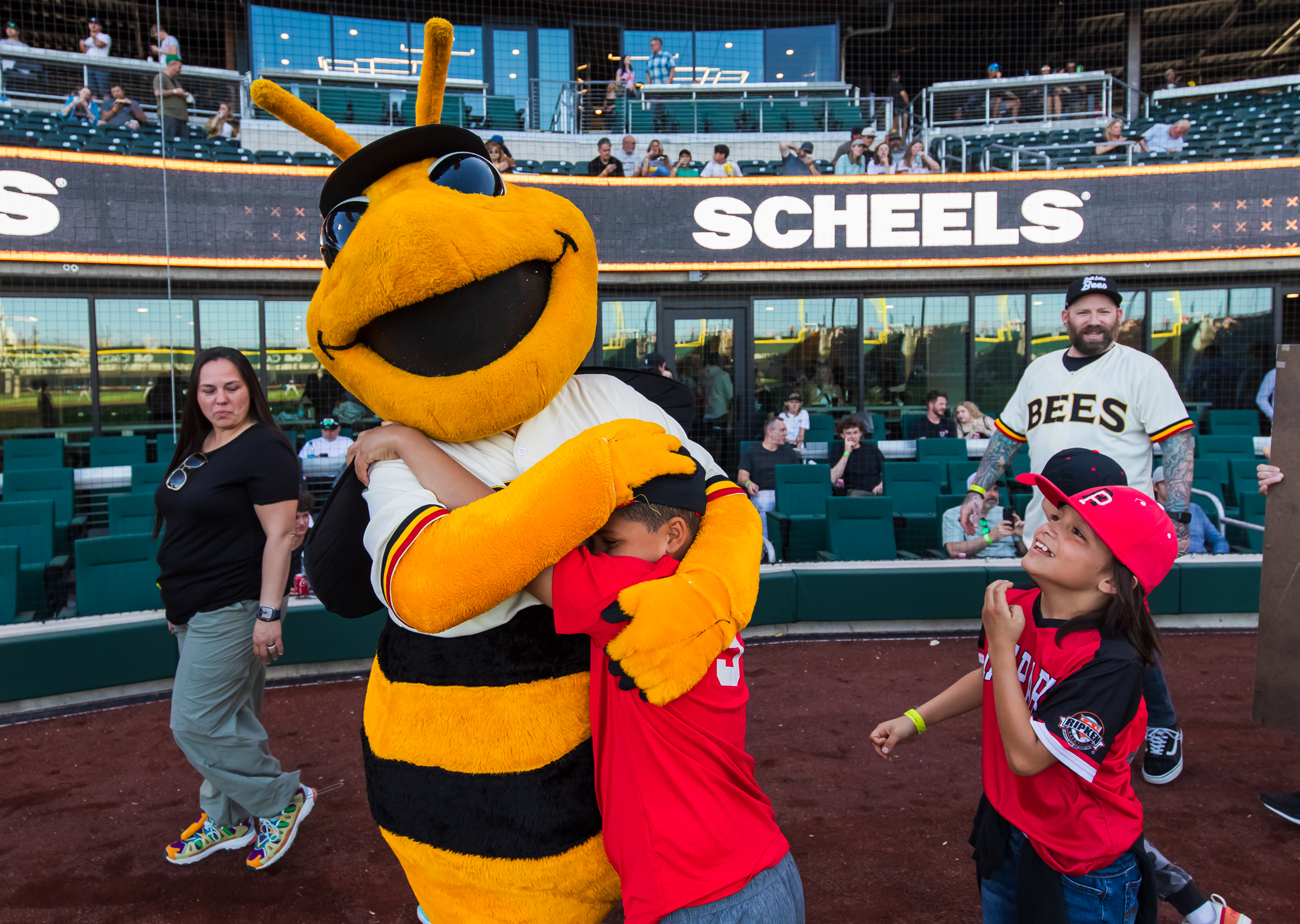 Rose Park Baseball players run up to hug Salt Lake Bees mascot Bumble before a game at The Ballpark at America First Square in South Jordan on Friday.
