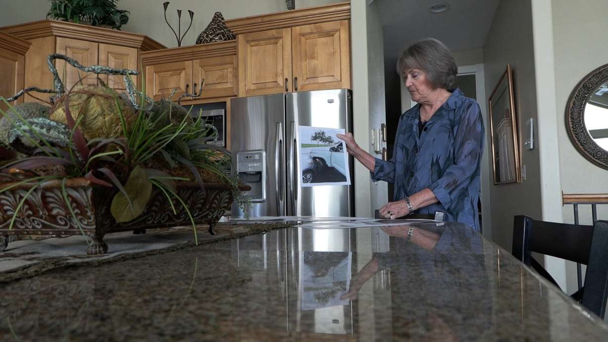 Debbie Sanich holds up a photo showing her collision with another driver in Hawaii. Though she was not at fault and the other driver’s insurance paid for the damage, she was on the hook for $1,256 in fees.