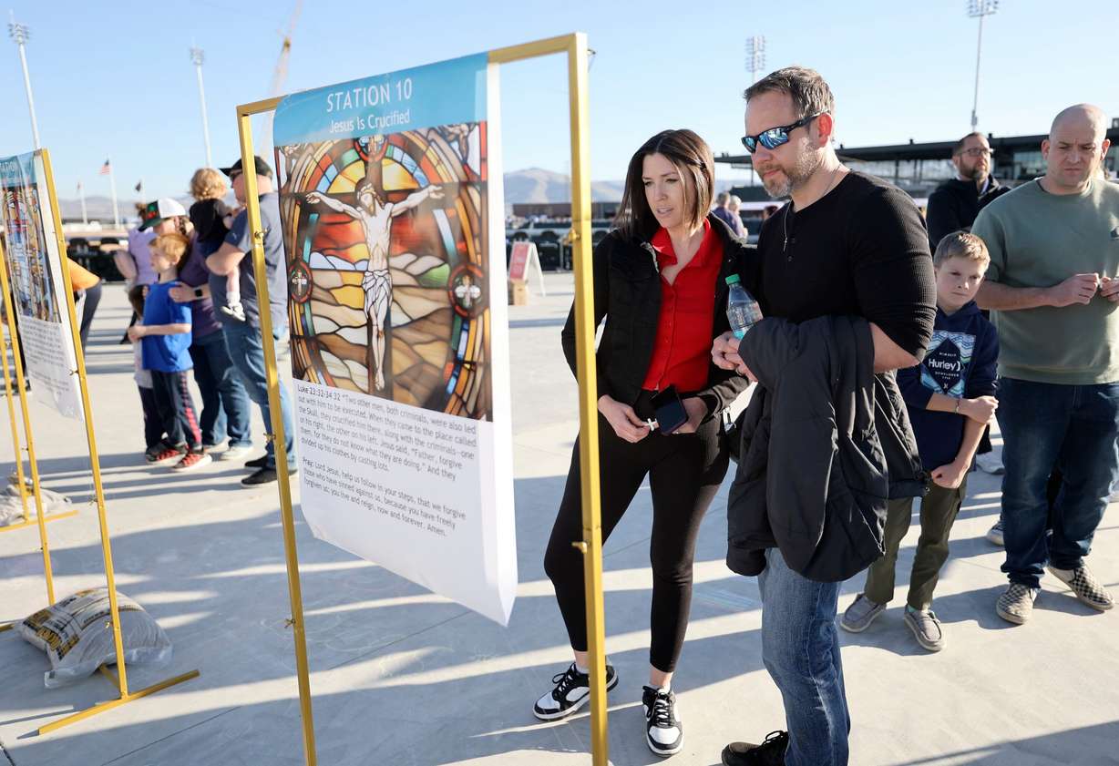 Amy and Shane Egan, of Draper, go through the Stations of the Cross at the Why I Believe Interfaith Easter Celebration at the Ballpark at America First Square in South Jordan on Monday.