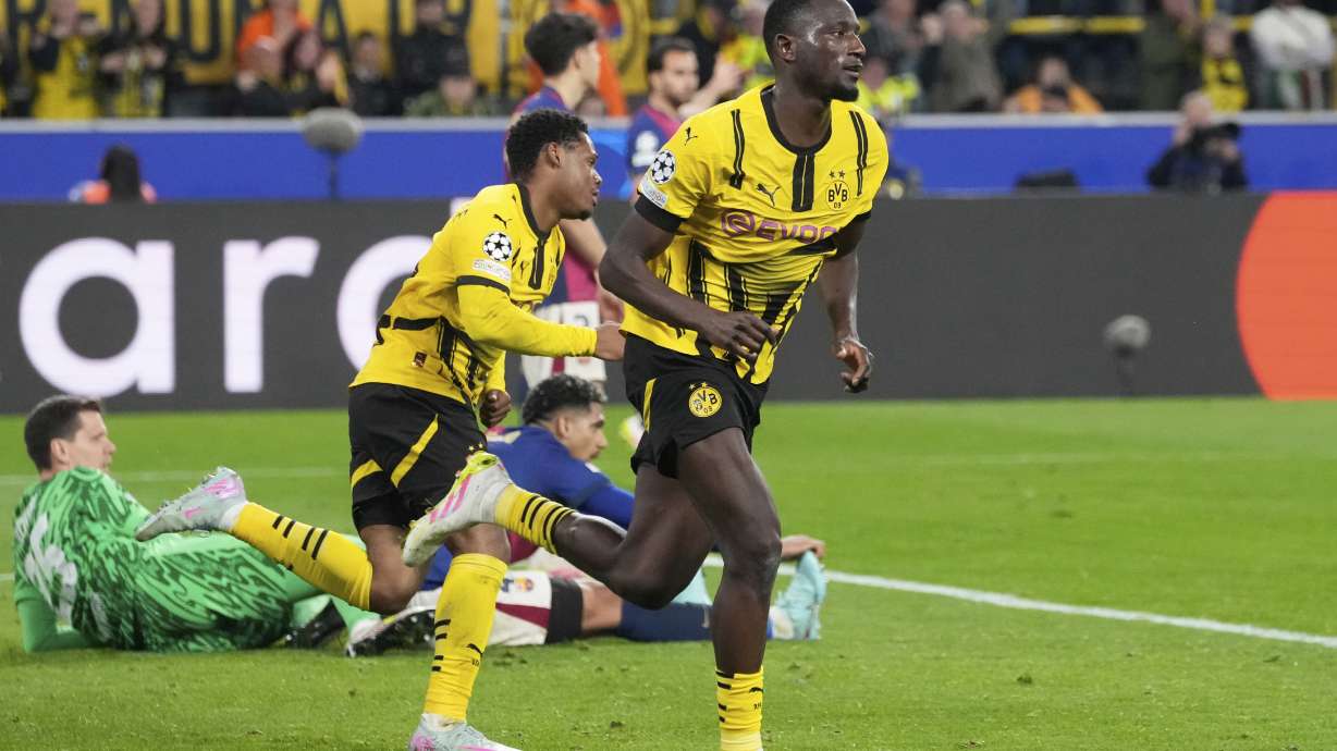 Dortmund's Serhou Guirassy, right, celebrates after scoring his side's third goal during the Champions League quarterfinals second leg soccer match between Borussia Dortmund and Barcelona, at the Signa-Iduna Park in Dortmund, Germany, Tuesday, April 15, 2025.