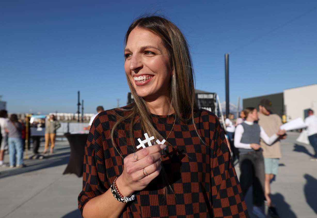 Taylor Stallings holds three crosses at the Why I Believe Interfaith Easter Celebration at the Ballpark at America First Square in South Jordan on Monday.