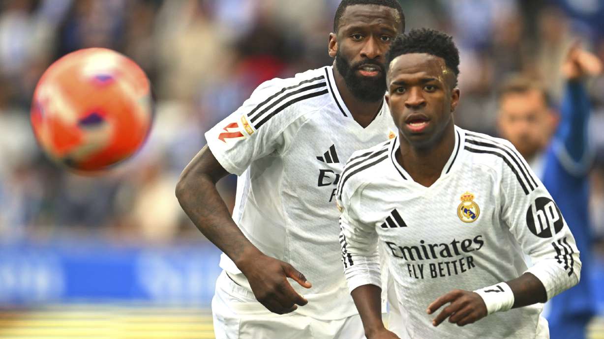 Real Madrid's Vinicius Junior, right and Antonio Rudiger chase the ball during a Spanish La Liga soccer match between Alaves and Real Madrid at the Mendizorroza stadium in Vitoria, Spain, Sunday April 13, 2025.