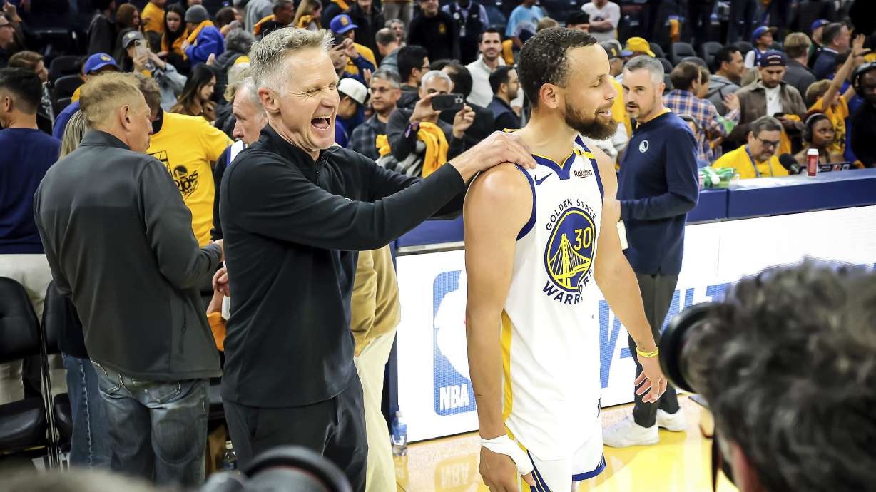 Golden State Warriors head coach Steve Kerr celebrates with Stephen Curry (30) after the Golden State Warriors defeated the Memphis Grizzlies 121-116 in the NBA play-in game at Chase Center in San Francisco, on Tuesday, April 15, 2025.