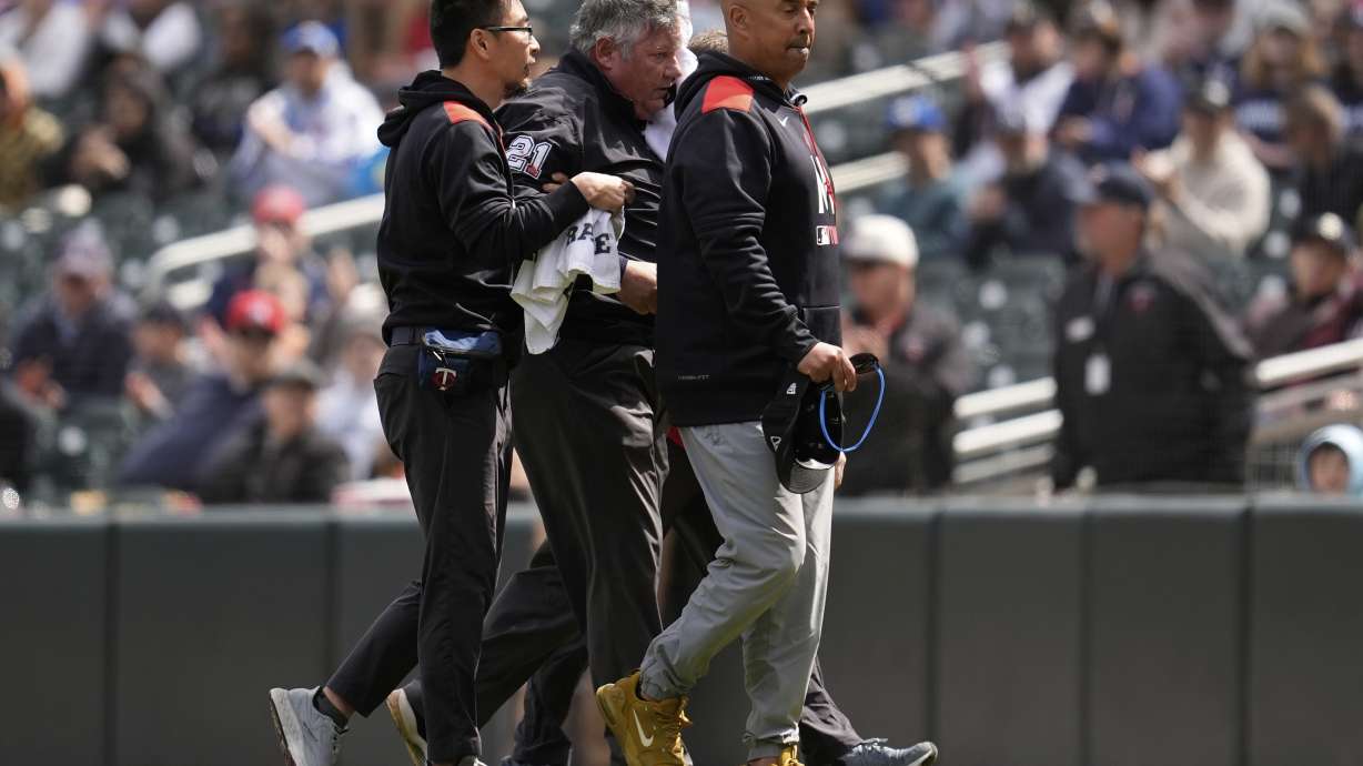 First base umpire Hunter Wendelstedt, center, walks off the field with medical staff after being hit by a foul ball during the seventh inning of a baseball game between the Minnesota Twins and New York Mets, Wednesday, April 16, 2025, in Minneapolis.
