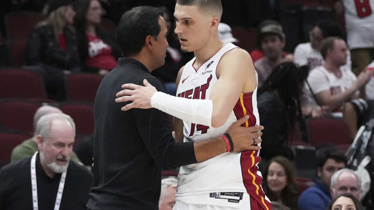 Miami Heat guard Tyler Herro, right, hugs head coach Erik Spoelstra during the second half of an NBA play-in tournament basketball game against the Chicago Bulls in Chicago, Wednesday, April 16, 2025.
