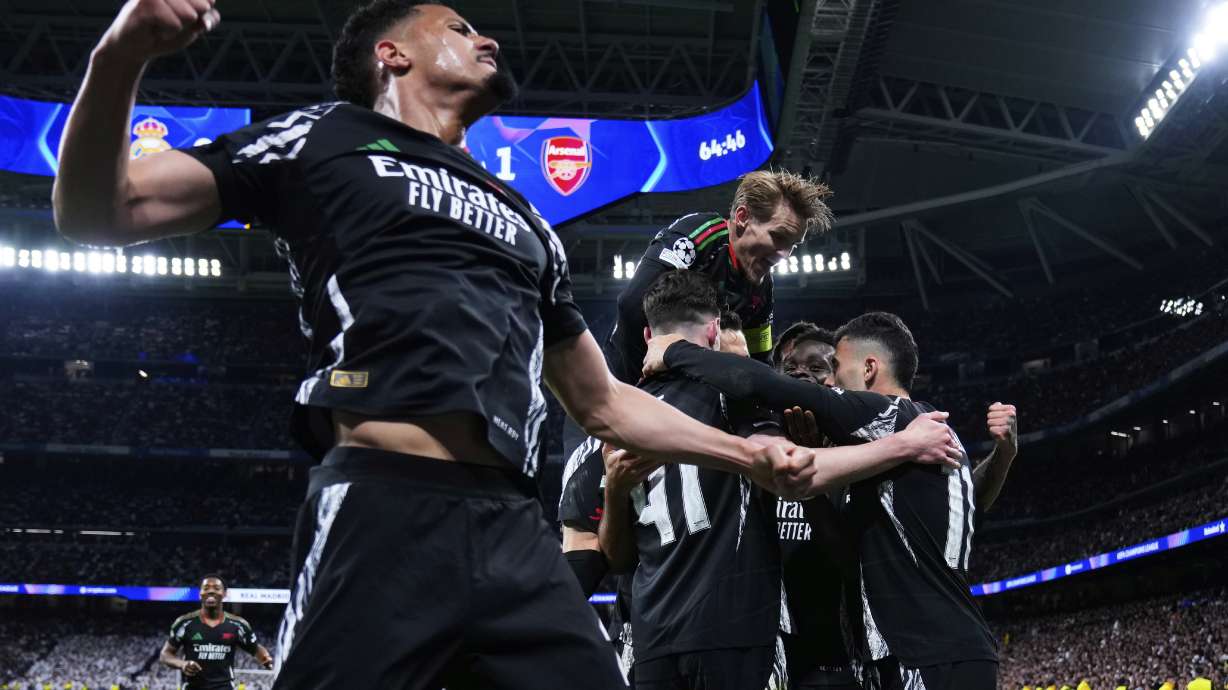 Arsenal players celebrate after Bukayo Saka, 2nd right, scored the opening goal during the Champions League quarterfinals second leg soccer match between Real Madrid and Arsenal at the Santiago Bernabeu stadium in Madrid, Wednesday, April 16, 2025.