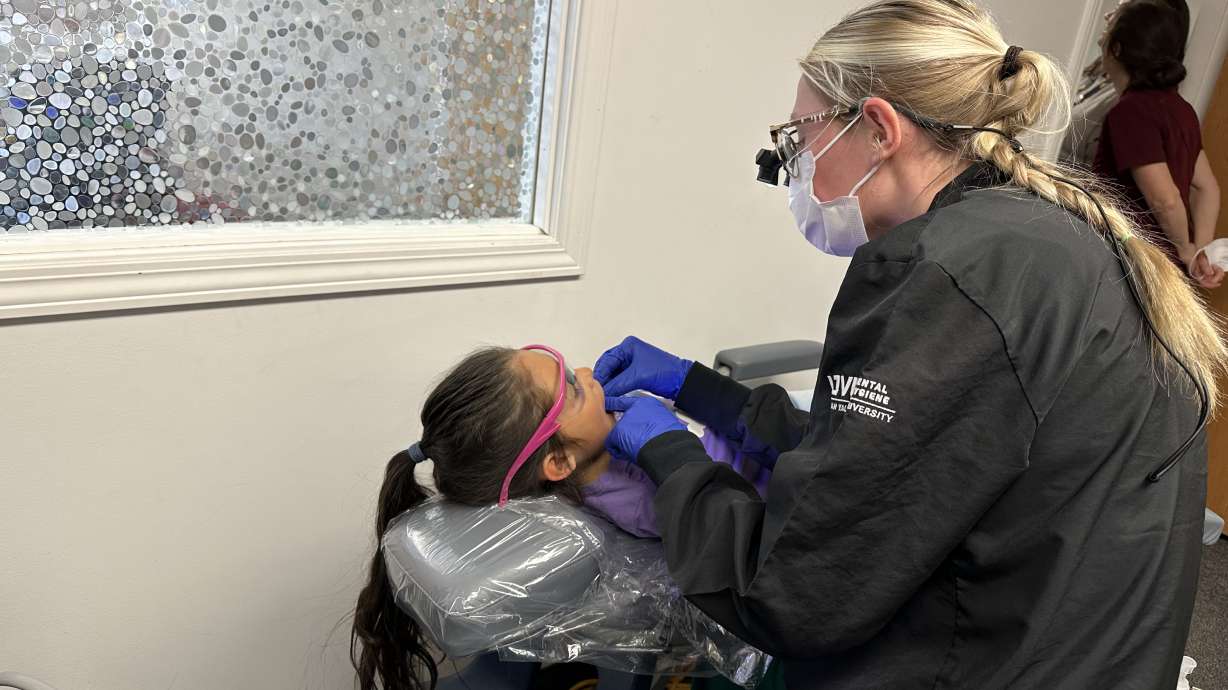 First-grader Melissa Cordova Patricio receives dental care from UVU student Gracie Miller at the Westmore Elementary School mobile clinic in Orem on Wednesday.