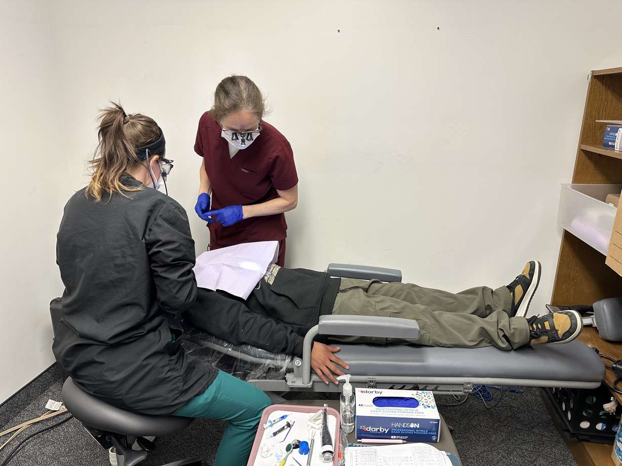 Instructor Deborah Dowd helps a UVU dental program student provide dental care for a Westmore Elementary School student as part of a mobile clinic in Orem on Wednesday.