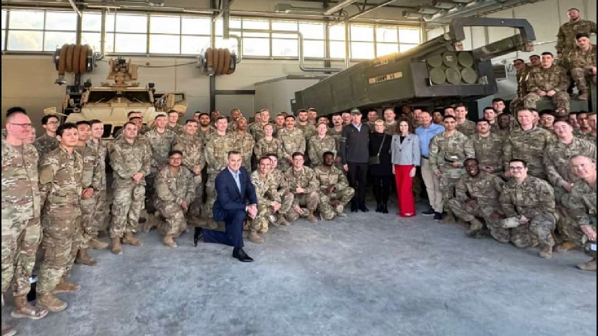 Sen. Mike Lee, dressed in a light blue shirt, poses with members of the U.S. military during a visit to Denmark, Estonia and Finland this week.