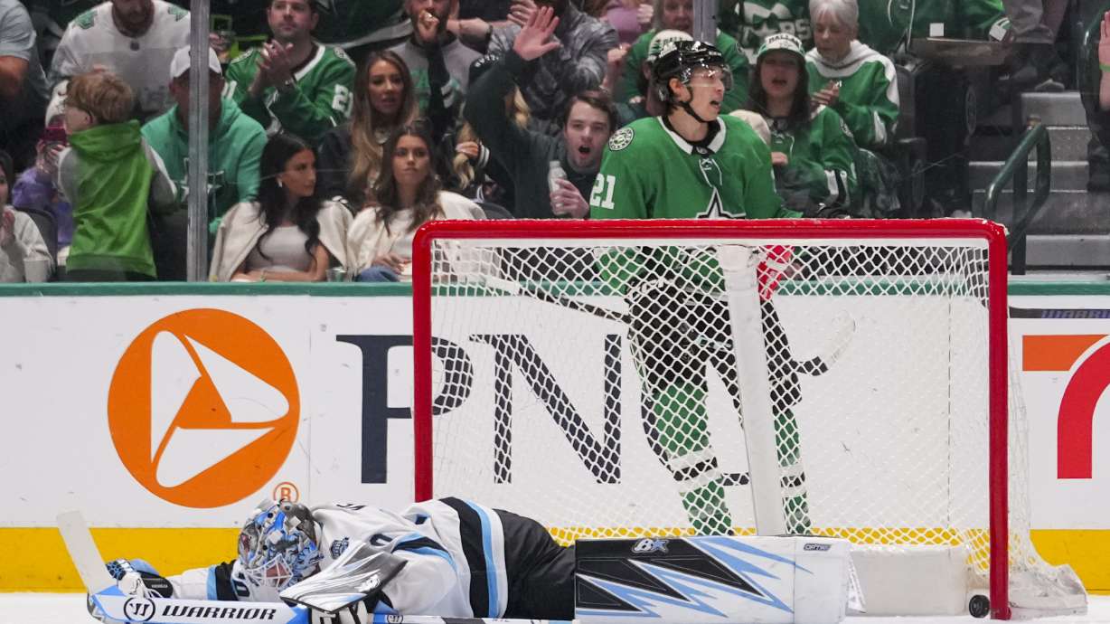 Utah Hockey Club goaltender Karel Vejmelka, bottom, reacts after giving up a goal to Dallas Stars left wing Jason Robertson, top, during the second period of an NHL hockey game Saturday, April 12, 2025, in Dallas.