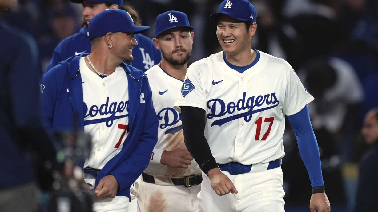 Los Angeles Dodgers' Miguel Rojas, left, and Shohei Ohtani chat after the Los Angeles Dodgers defeated the Colorado Rockies 8-7 in a baseball game Wednesday, April 16, 2025, in Los Angeles.