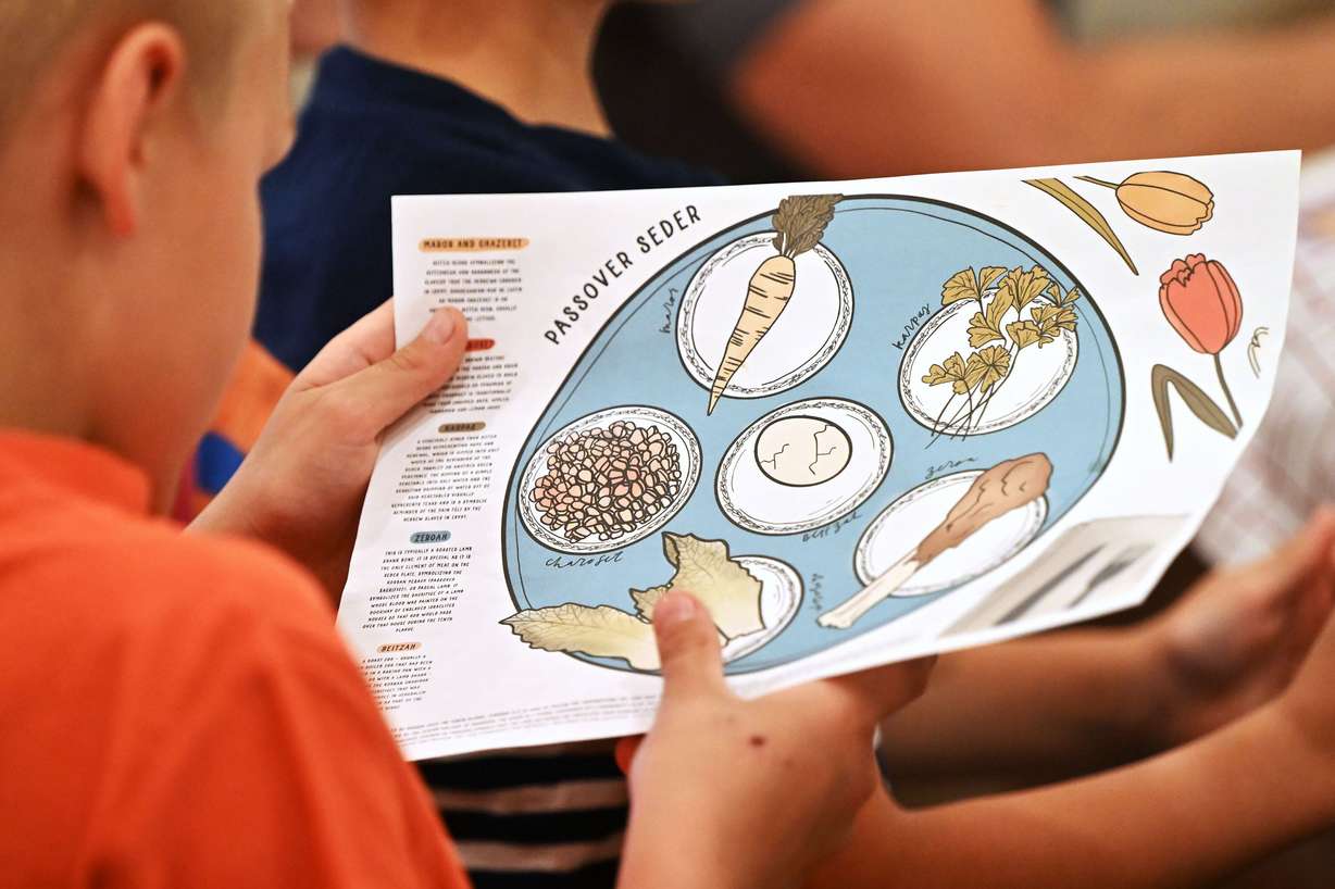 John Curtis reads about different foods that are part of the Passover tradition as the Curtis family takes part in a few Easter celebrations on Wednesday.