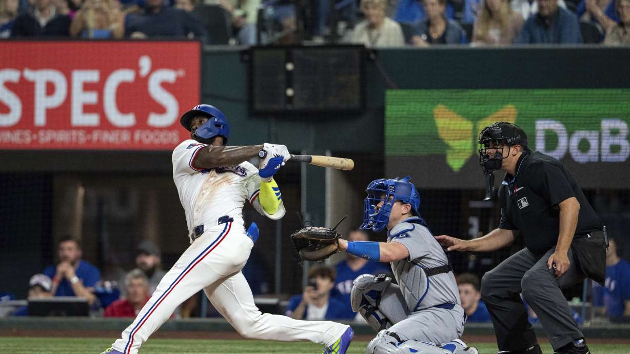 Texas Rangers' Adolis García follows through on a walk-off two run home run that scored Josh Smith off of Los Angeles Dodgers pitcher Kirby Yates during the ninth inning of a baseball game Saturday, April 19, 2025, in Arlington, Texas.