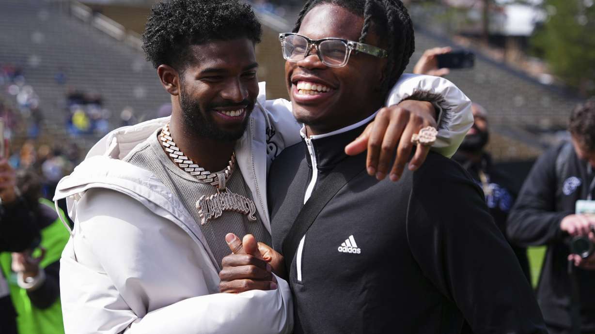Shedeur Sanders, left, and Travis Hunter, right, react to their jersey retirements during Colorado's NCAA college football spring game, Saturday, April 19, 2025, in Boulder, Colo.