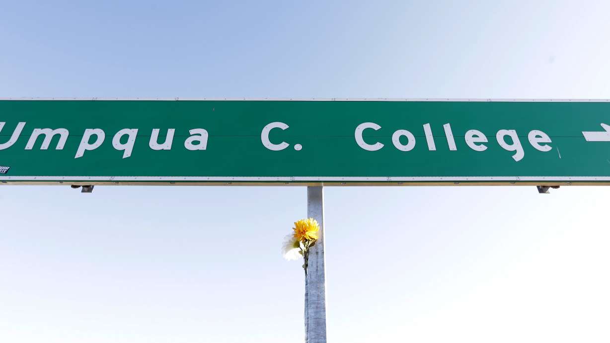 FILE - A flower is posted on a direction sign to Umpqua Community College, Oct. 2, 2015, in Roseburg, Ore.