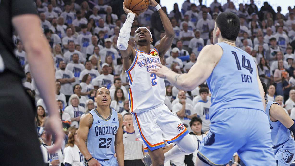 Oklahoma City Thunder guard Shai Gilgeous-Alexander (2) looks to shoot between Memphis Grizzlies guard Desmond Bane (22) and center Zach Edey (14) during the first half in Game 1 of an NBA first-round playoff series, Sunday, April 20, 2025, in Oklahoma City.