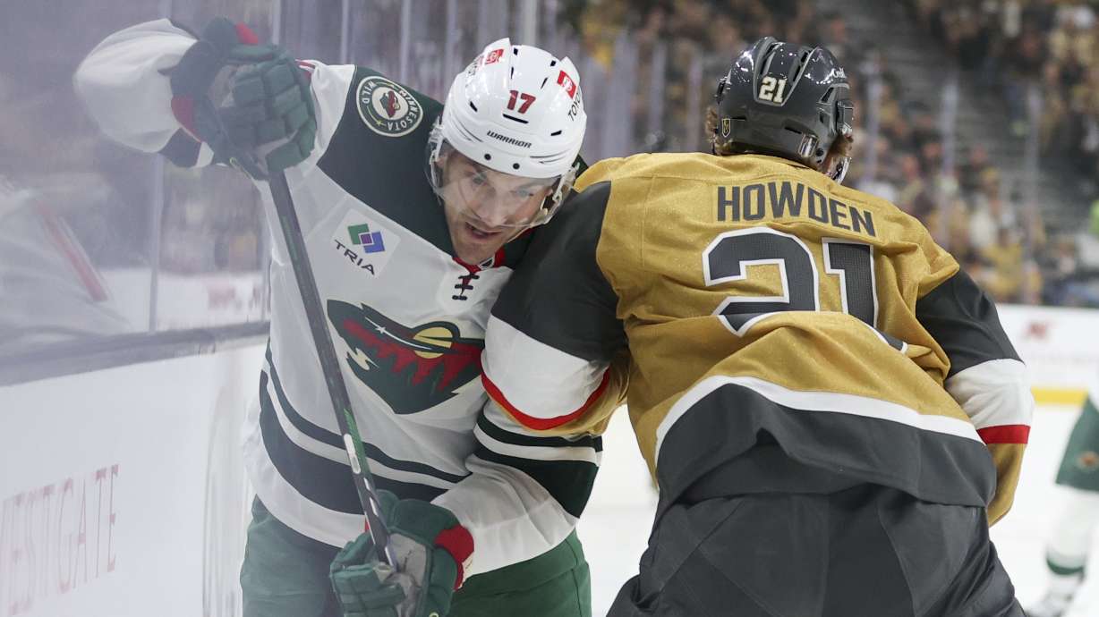 Vegas Golden Knights center Brett Howden (21) checks Minnesota Wild left wing Marcus Foligno (17) during the first period in Game 1 of an NHL hockey Stanley Cup first-round playoff series Sunday, April 20, 2025, in Las Vegas.