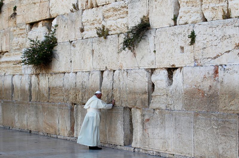 Pope Francis touches the stones of the Western Wall, Judaism's holiest prayer site, in Jerusalem's Old City on May 26, 2014. Pope Francis died Monday.