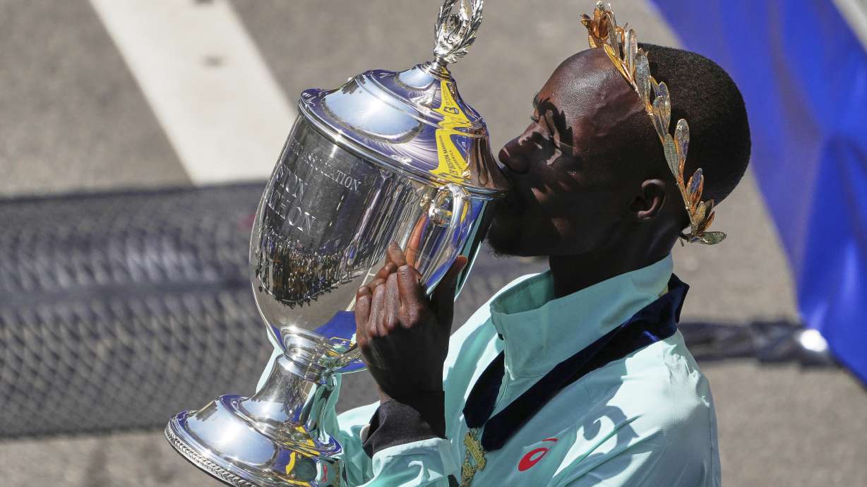 Boston Marathon winner John Korir, of Kenya, kisses the trophy while celebrating after the race, Monday, April 21, 2025, in Boston.