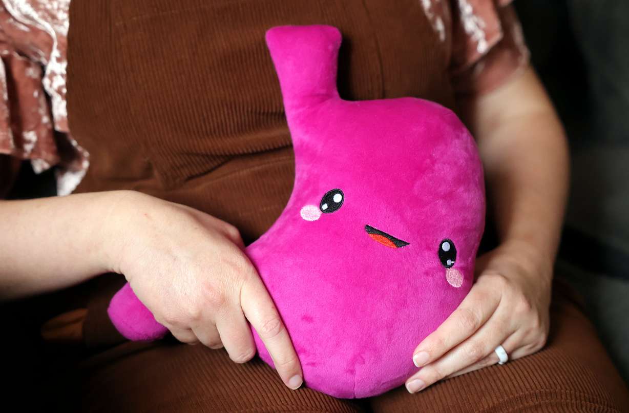 Chari Dickson holds a stuffed “security stomach” for a portrait, a week after having her own stomach removed, at her father’s home in Mapleton on April 16. She has the SMAD4 gene mutation, which leads to polyps in the digestive tract and eventually cancer.