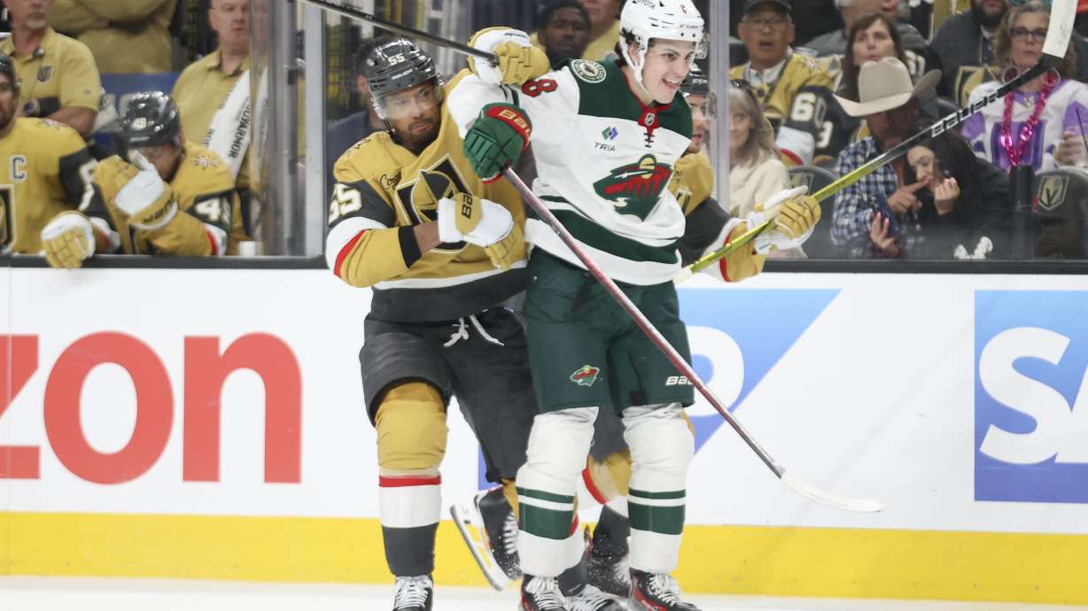 Vegas Golden Knights right wing Keegan Kolesar (55) and Minnesota Wild defenseman Zeev Buium (8) get tangled up during the second period in Game 1 of an NHL hockey Stanley Cup first-round playoff series Sunday, April 20, 2025, in Las Vegas.
