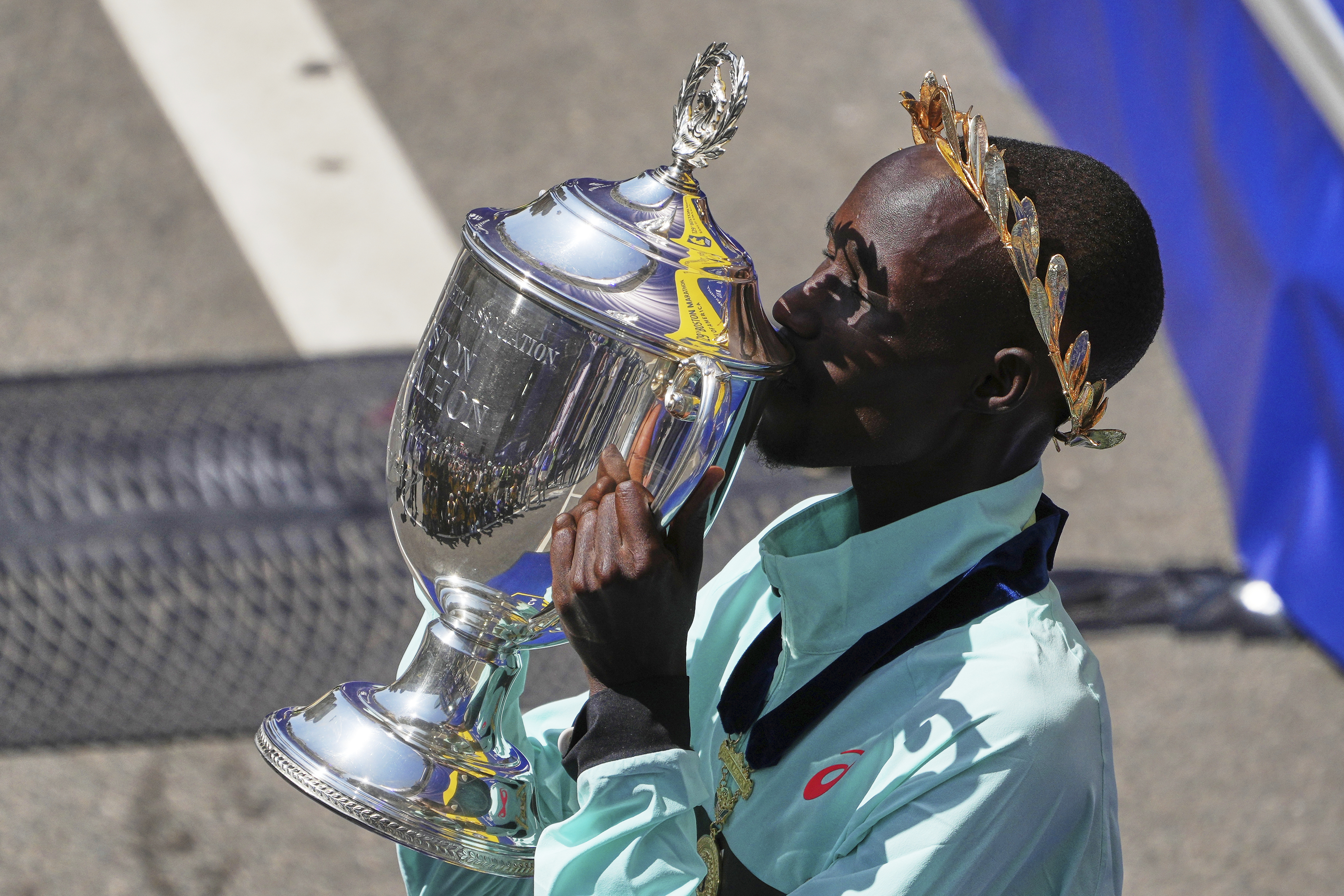 Boston Marathon winner John Korir, of Kenya, kisses the trophy while celebrating after the race, Monday, April 21, 2025, in Boston.