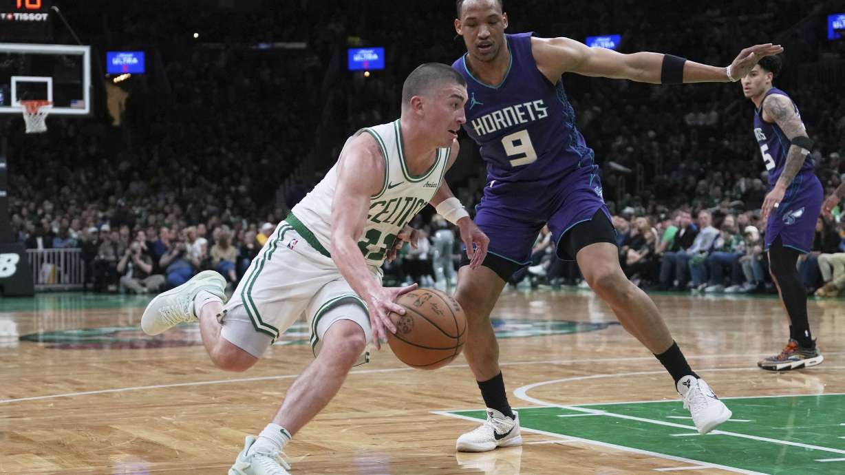 Boston Celtics guard Payton Pritchard, left, drives to the basket against Charlotte Hornets guard Wendell Moore Jr. (9) during the second half of an NBA basketball game, Friday, April 11, 2025, in Boston.