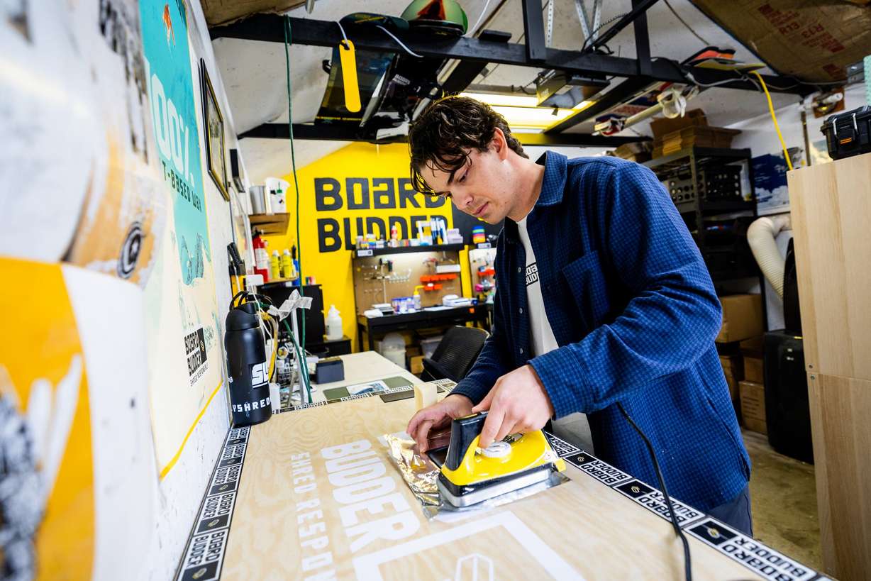 Zeke Greer, co-founder of Board Budder, a ski and snowboard wax company, waxes a polyethylene base to test their wax formulas inside the garage of Erik Smith, founder and CEO of Board Budder and University of Utah Master of Business Creation student, in Salt Lake City on Friday, April 18.
