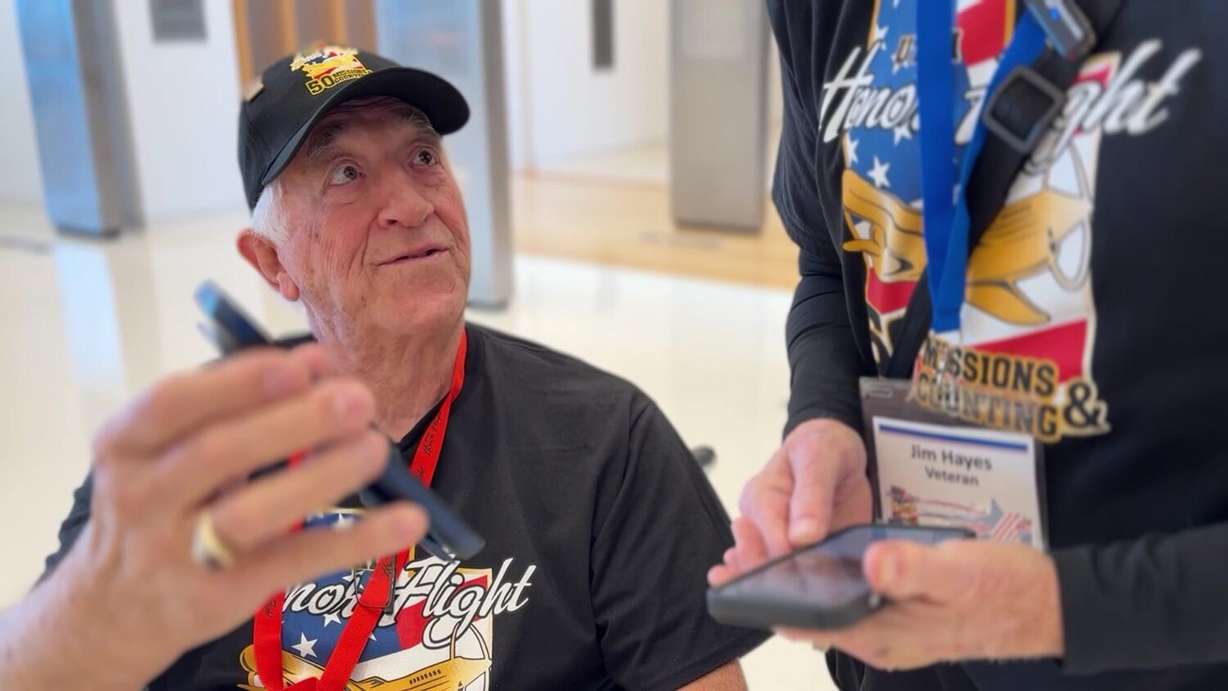 Merrill Wells showing Jim Hayes photos of his time in the military.