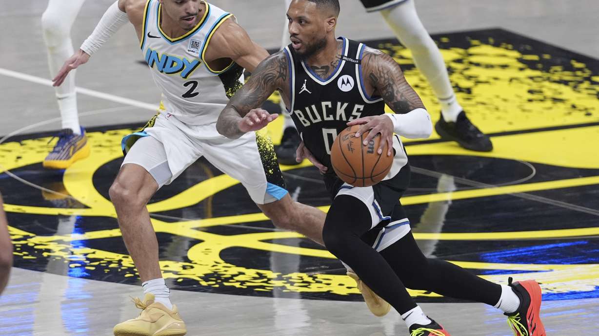 Milwaukee Bucks guard Damian Lillard (0) drives on Indiana Pacers guard Andrew Nembhard (2) during the first half of a first-round NBA basketball playoff game in Indianapolis, Tuesday, April 22, 2025.