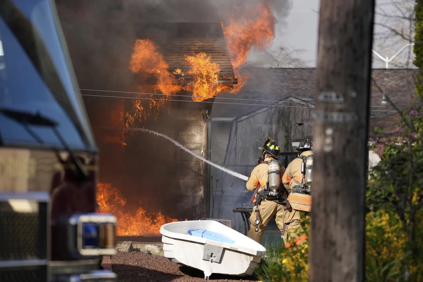 Firefighters battle a house fire in Lacey Township, N.J., Wednesday. A fast-moving wildfire was burning in New Jersey’s Pine Barrens, but officials on Wednesday lifted earlier evacuation orders.