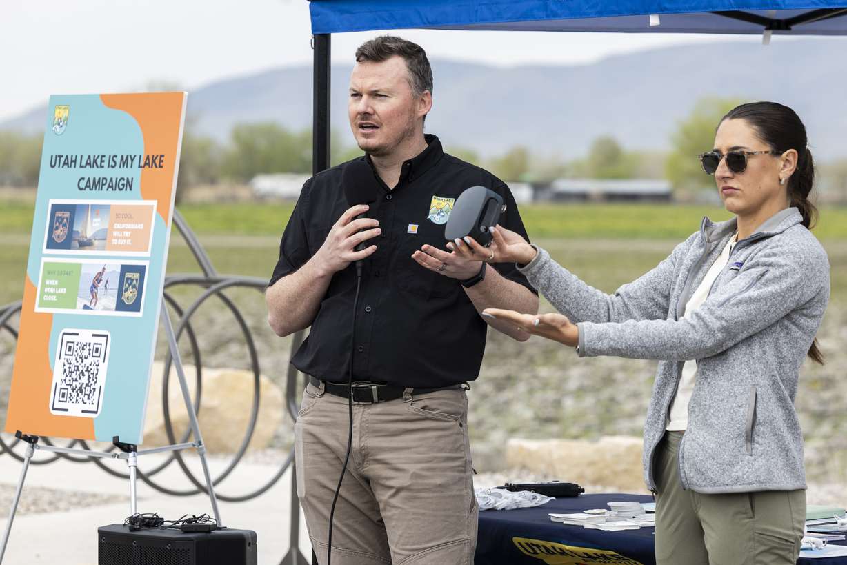 Sam Braegger, deputy director of the Utah Lake Authority, speaks as Addy Valdez, a conservation biologist with the Utah Lake Authority, shows an eco-counter that records how many people or cars pass by it during a press conference held near Utah Lake in Provo on Wednesday.