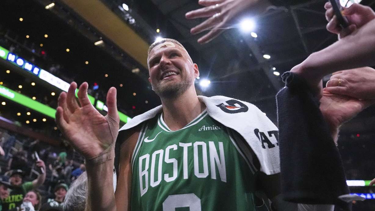 With his head bandaged after an injury, Boston Celtics center Kristaps Porzingis (8) is congratulated by fans after defeating the Orlando Magic in game 2 of a first-round NBA playoff basketball series, Wednesday, April 23, 2025, in Boston.
