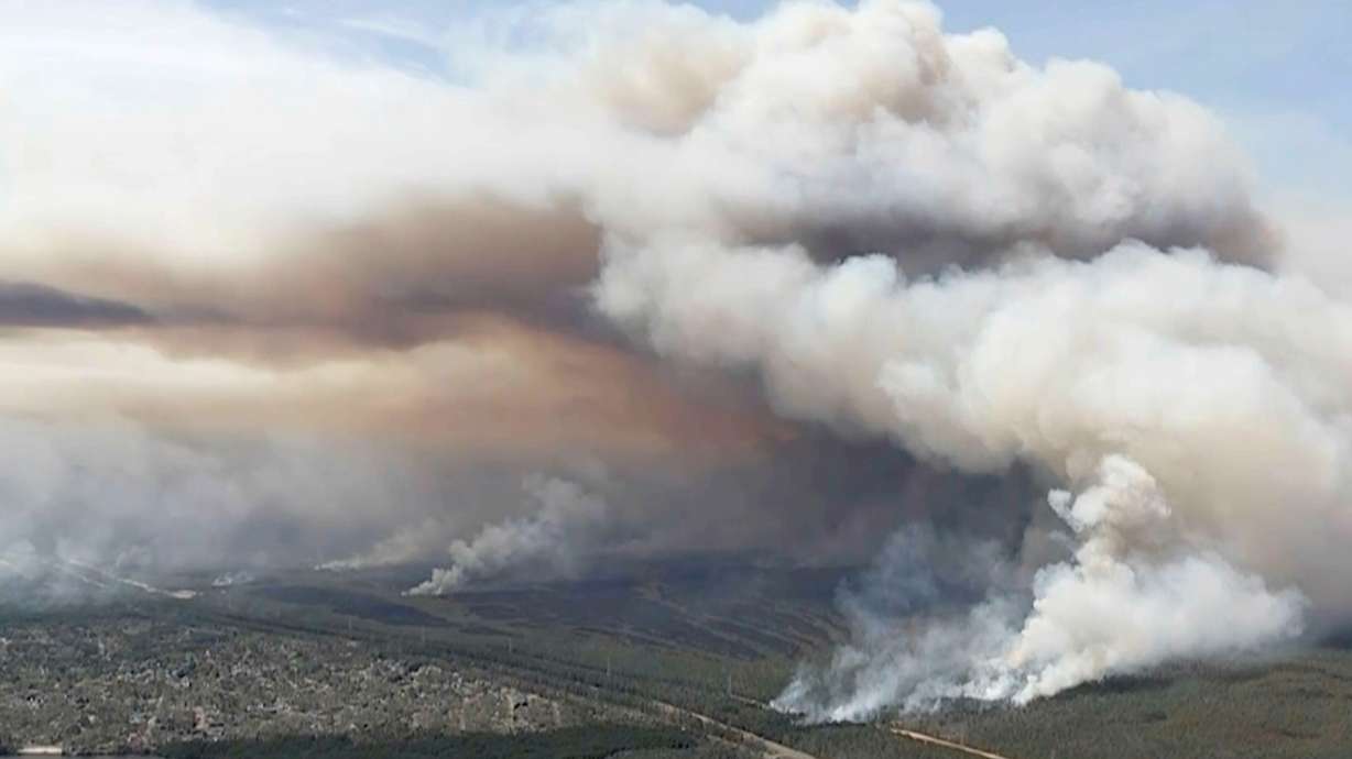 Smoke rises from wildfires in Ocean County, N.J., Wednesday. Authorities say a man set wooden pallets on fire and failed to properly put them out in New Jersey's Pine Barrens, sparking a quick-moving wildfire.