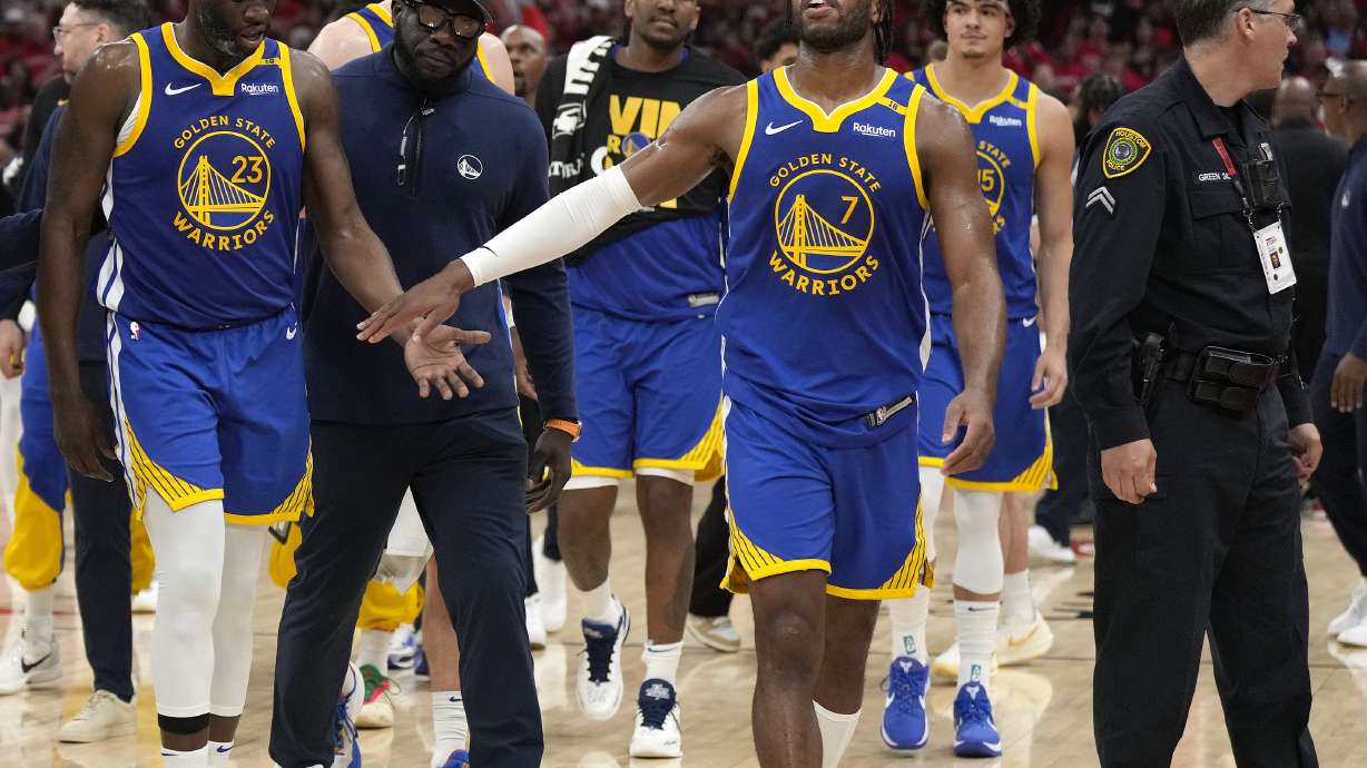 Golden State Warriors forward Draymond Green (23) is escorted back to the bench by a coach and guard Buddy Hield (7) after a brief scuffle with the Houston Rockets during the second half of Game 2 of an NBA basketball first-round playoff series against the Houston Rockets in Houston, Wednesday, April 23, 2025.