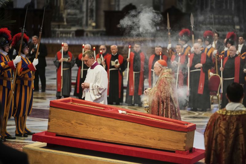Cardinal Camerlengo Kevin Joseph Farrell spreads incense around the body of Pope Francis inside St. Peter's Basilica at the Vatican, Wednesday, where he will lie in state for three days.