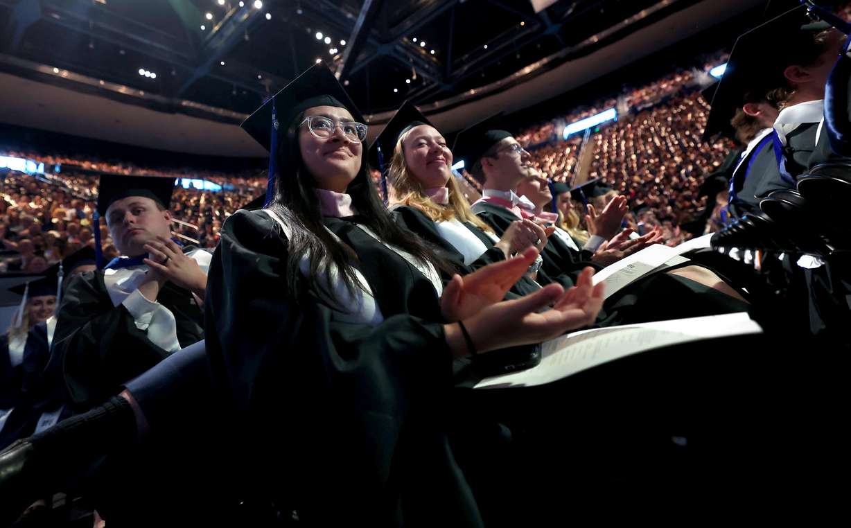 Renee Chiu Gastelum, graduating with a master’s degree in organ performance, claps during Brigham Young University’s commencement ceremony, held at the Marriott Center in Provo on Thursday, April 24.