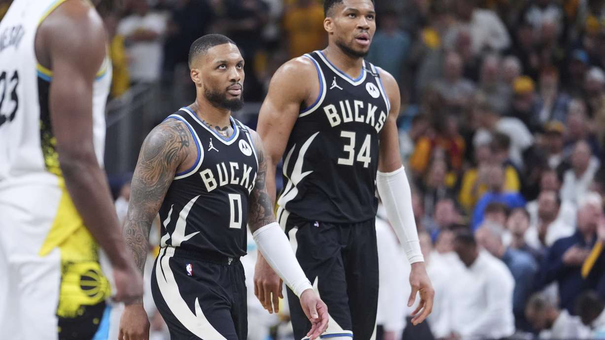 Milwaukee Bucks guard Damian Lillard (0) and forward Giannis Antetokounmpo (34) walk to the bench during the second half of a first-round NBA basketball playoff game against the Indiana Pacers in Indianapolis, Tuesday, April 22, 2025.