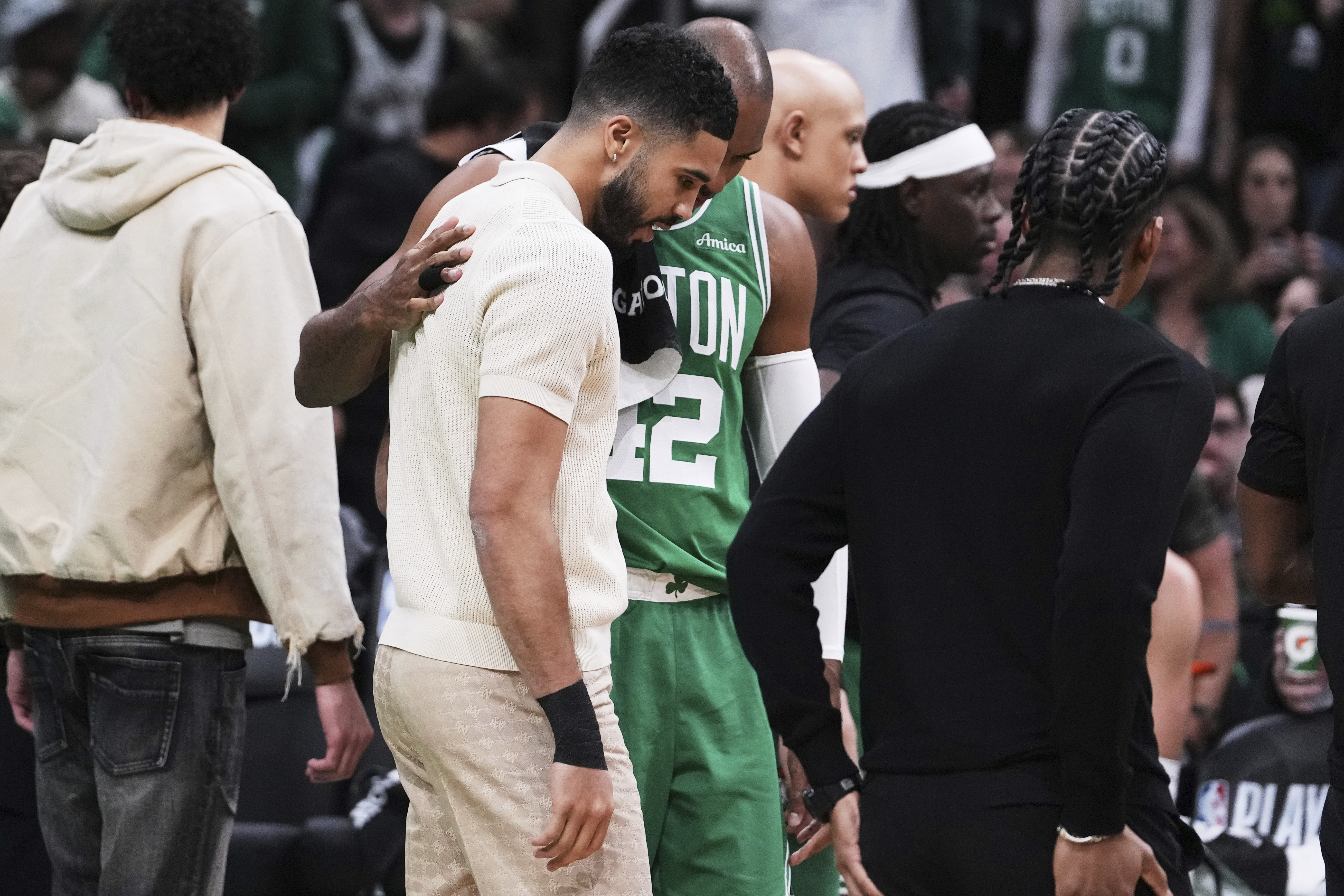 Boston Celtics forward Jayson Tatum, who is sidelined with an injury, gets a pat on the back from center Al Horford during the first half in game 2 of a first-round NBA playoff basketball series, Wednesday, April 23, 2025, in Boston.