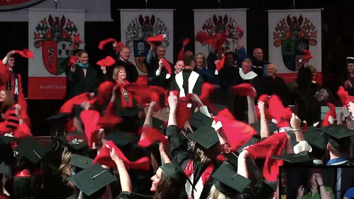 Southern Utah University graduates wave red "Terrible Towels" after Pittsburgh Steelers player Miles Killebrew finishes his commencement address at SUU's 2025 graduation.