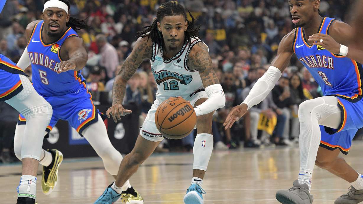 Memphis Grizzlies guard Ja Morant (12) handles the ball between Oklahoma City Thunder guards Shai Gilgeous-Alexander (2) and Luguentz Dort (5) in the first half of Game 3 of an NBA first-round playoff series Thursday, April 24, 2025, in Memphis, Tenn.